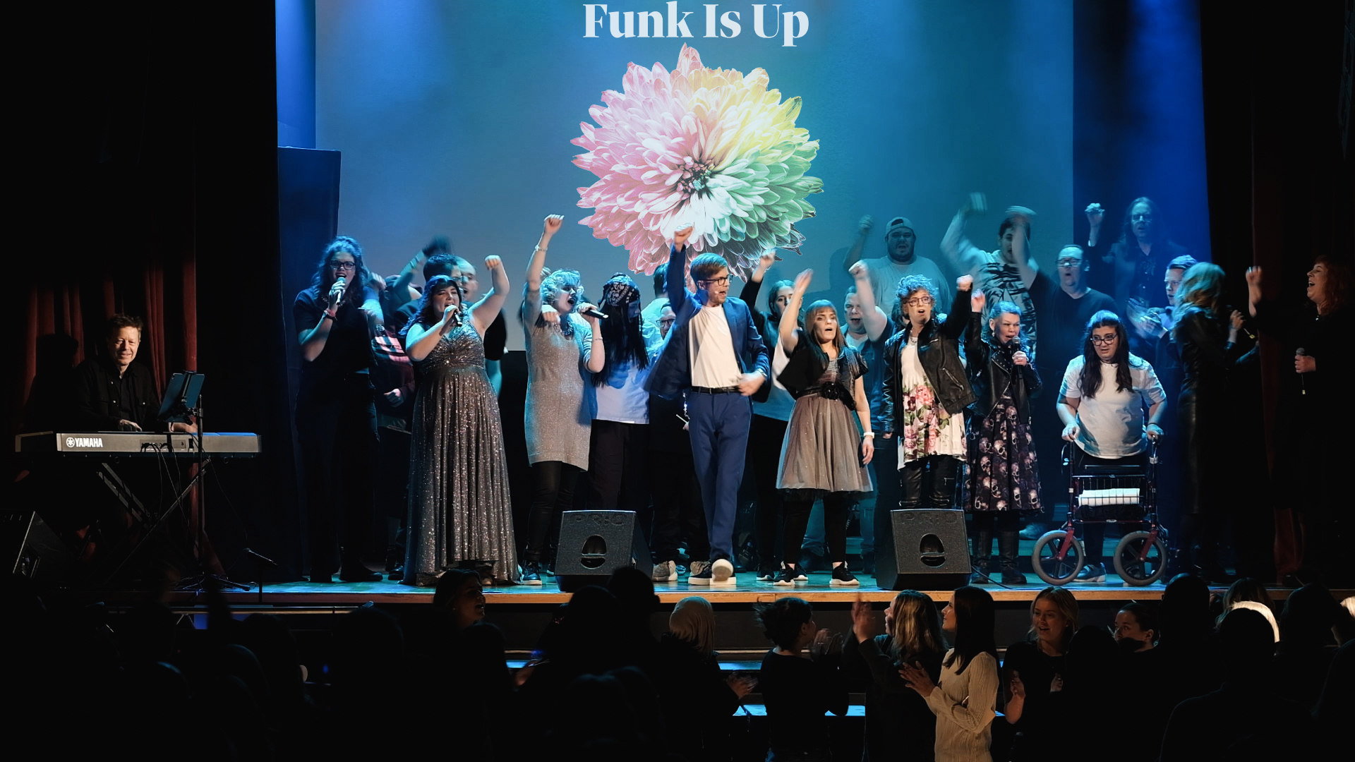 En kör på scen. På skärmen i bakgrunden står det Funk is up!